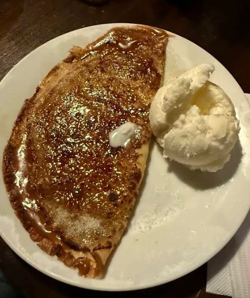 Panqueque con dulce de leche caramelizado y una bocha de helado